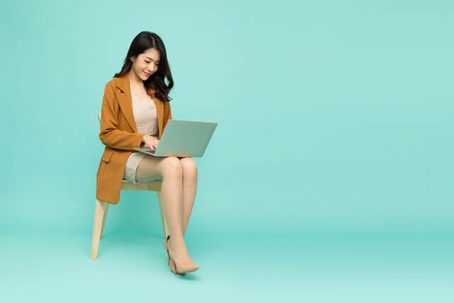여성분이 의자 앉아서 노트북을 하는 모습