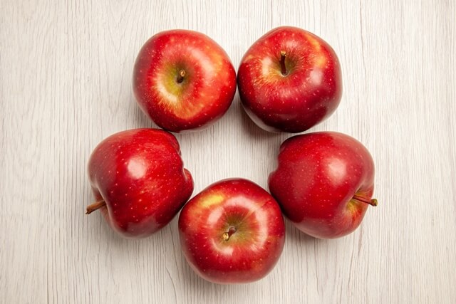 테이블에 사과 5개가 나란히 놓여있다.